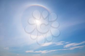 Sun with circular rainbow. Sun halo occurring due to ice crystals in atmosphere. Nature sky composition.