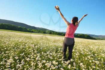 Happy girl in daisy wheel spring flower field. Emotional and nature scene. 
