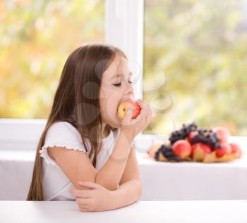 Cute little girl eating an apple