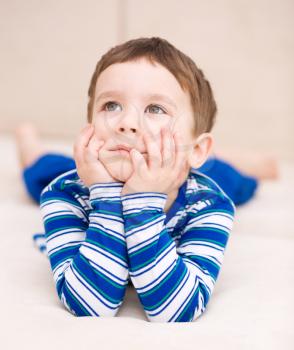 Portrait of a cute little boy supporting his head with hands