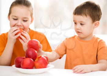 Happy cute children eating red apple