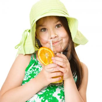 Cute girl is drinking orange juice using straw, isolated over white