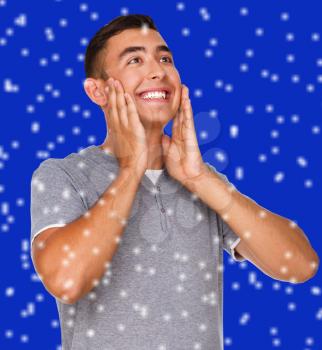 Cheerful young man, over blue snowy background