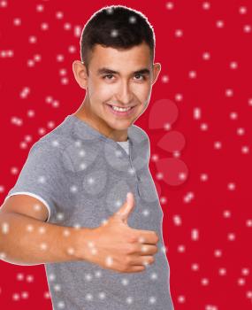 Cheerful young man, over red snowy background