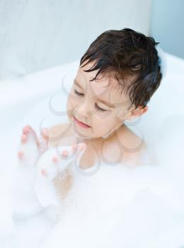 Small child bathes in a bathroom