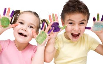Cute boy and girl showing her hands painted in bright colors, isolated over white