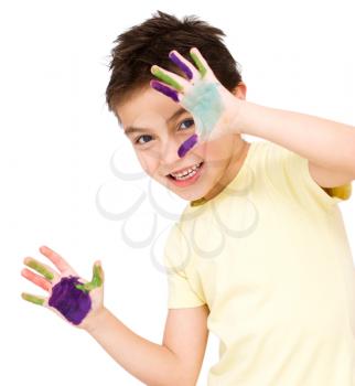 Portrait of a cute boy showing her hands painted in bright colors, isolated over white
