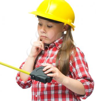 Happy cute girl as a construction worker with tape measure, isolated over white