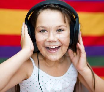 Cute girl is enjoying music using headphones and closed her eyes