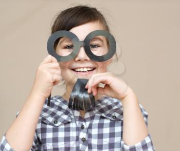 Funny girl with fake beard and glasses. Happy child playing in home