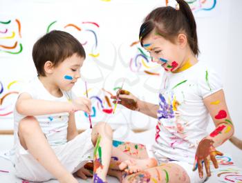 Cute boy and girl showing her hands painted in bright colors