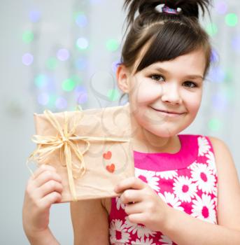 Happiness, health and love concept - smiling girl holding present