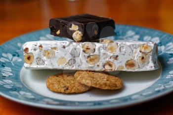 Oriental sweets. Hazelnuts drenched in powdered sugar with honey. Biscuits and chocolate