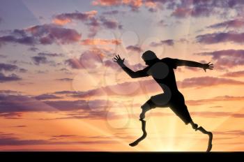 Disabled sportsman with two prosthetic running on sunset background. Concept sport and willpower
