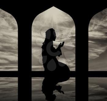 The concept of the Islamic religion. Silhouette of man praying at the Town Hall and reflection