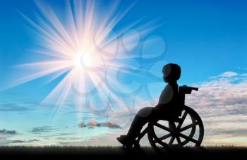 Boy sitting in wheelchair on street day. Disabled children concept