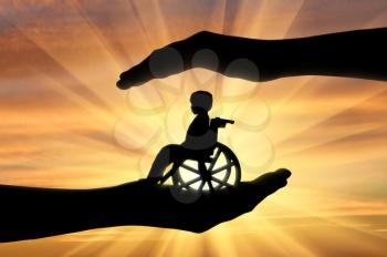 Disabled child in a wheelchair in the hands of man. Concept of care and custody