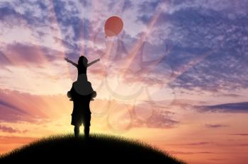Young dad stands on hill on shoulders of child hold balloon and sunset. Concept happy family