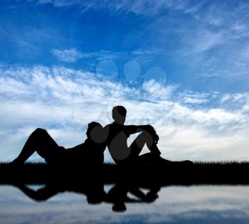 Concept of gay people. Silhouette of two gay holidaymakers near a river on a background of blue sky