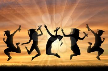 Graduates jumping for joy sunset in hands of diploma. Graduation concept