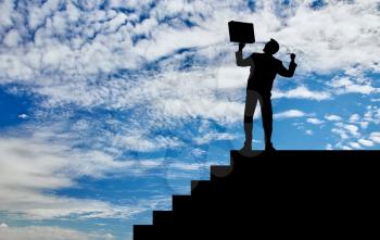 Business success concept. Silhouette of a happy businessman with a briefcase in his hands at the height of the steps on the sky background