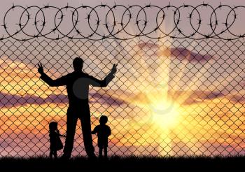 Concept of the refugees. Silhouette refugees father and two hungry children on the background of the fence