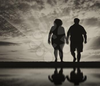Couple with overweight on sunset background. concept of obesity