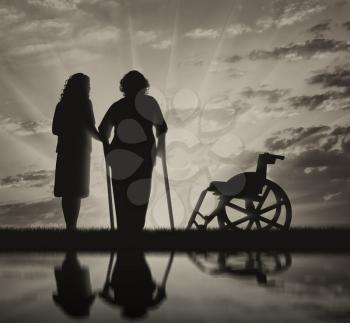 Disabled persons woman on crutches in reflection and nurse helps her. Concept of disability