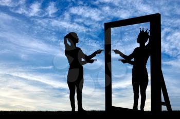 A silhouette of a narcissistic woman raises her self-esteem in front of a mirror. The concept of narcissism and selfishness