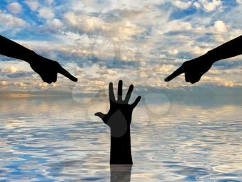 Silhouette of two hands showing a finger and condemning the hand of a sinking person asking for help. The concept of a selfish society, a social problem