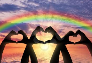 Altruism concept. Three pairs of hands show a heart symbol on a rainbow background
