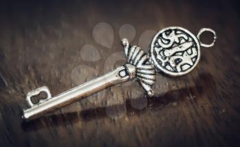 Beautiful silver key on a wooden background. Photo tinted.