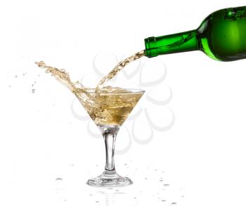 White wine pouring from the bottle intro the glass on white background