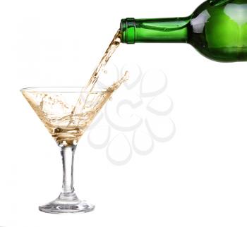 White wine pouring from the bottle intro the glass on white background