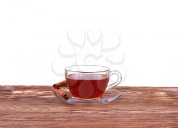 Glass cup of  tea with cinnamon sticks isolated on white