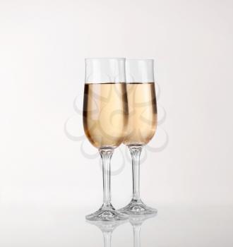 Two glasses of champagne over light gray white background