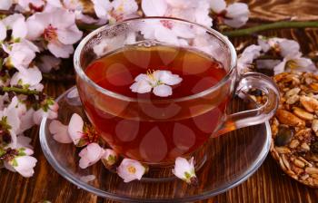 tea and a branch of cherry blossoms on a wooden