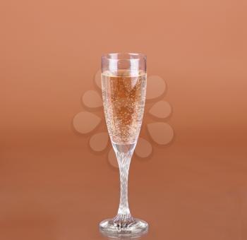 a glass of champagne on a beige background