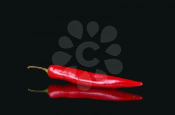 Red hot pepper and reflection on black background