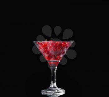 Water with red currants on a black background