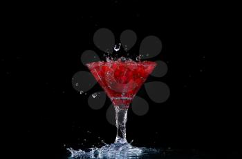 Water with red currants on a black background