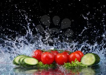 Salad, tomato and cucumber with water drop splash