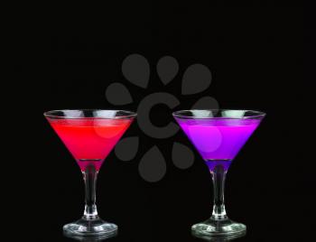 Cosmopolitan cocktail in nice red, purple and blue in front of a black background