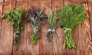 Fresh herbs hanging over wooden background