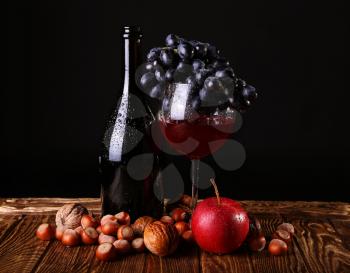 Autumn Collection. Glass of wine with boutle on  dark background