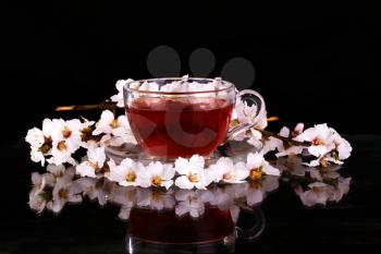 Cup of black tea with and cherry blossom. Copy space background.