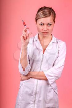 Doctor, girl, syringe injection. Nurse. Portrait of young woman in doctor's smock and with syringe.