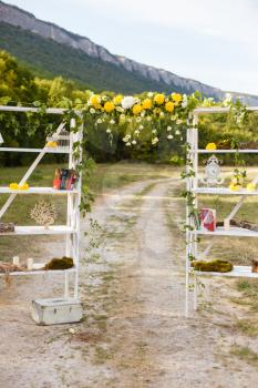 Happy outdoor Wedding Ceremony Scene for a summer mountain wedding. Wedding aisle, decorated wedding alter and flower decorations with mountains in the background. Wedding color pear