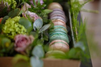 Macaroons in turquoise box with fresh flowers. Stylish powder colors. On the eve of Mother's Day and Women's Day