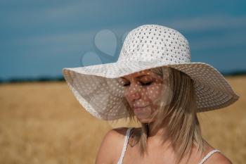 nature, summer holidays, vacation and people concept - face of happy smiling woman or teenage girl n in hat on cereal field